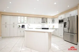 All-White Cabinets, Counter-tops and Floor Tiles Kitchen - Altima Homes Inc.