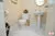 All-White Marble Floor Guest Bathroom - Altima Homes Inc.