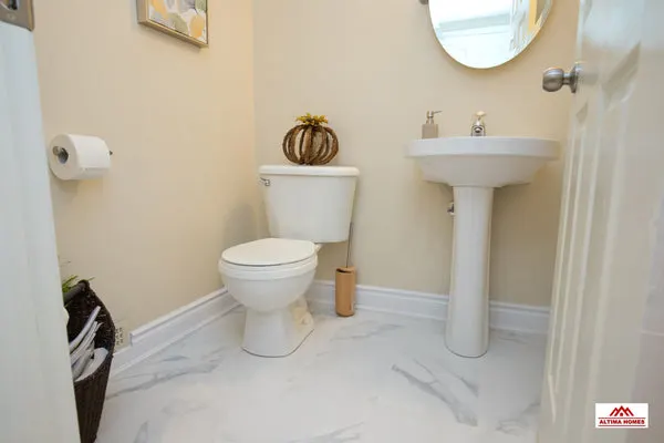 All-White Marble Floor Guest Bathroom - Altima Homes Inc.