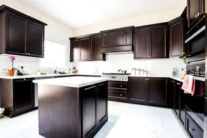 Large Kitchen with Brown Cabinets & White Quartz Counter - Altima Homes Inc.