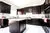 Large Kitchen with Brown Cabinets & White Quartz Counter - Altima Homes Inc.