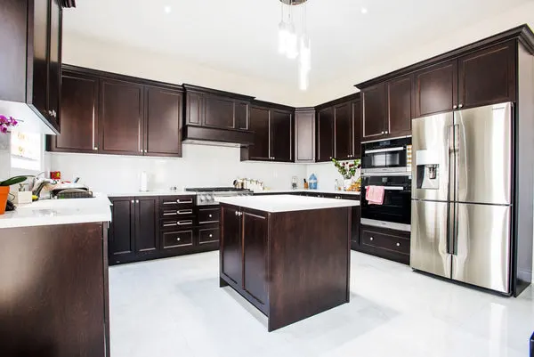 Large Kitchen with Brown Cabinets & White Quartz Counter - Altima Homes Inc.
